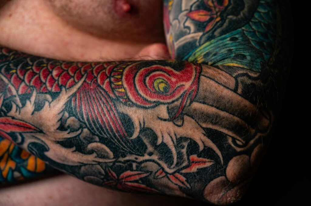 pexels-photo-2134085-2134085 Close-up of a colorful Japanese style tattoo on a man's arm, featuring dragons and vibrant colors.